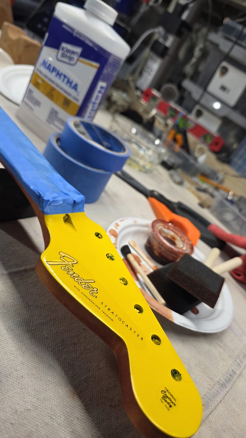 Stratocaster headstock mid-refinish in bright yellow