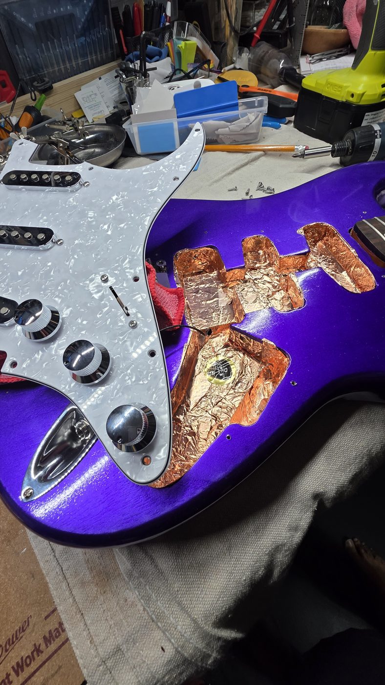 Copper shielding foil being applied inside a guitar's control cavity